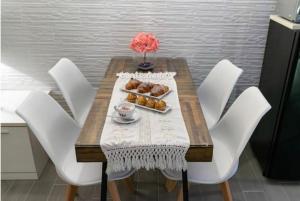 加拉蒂纳Salento Home的一张桌子、白色椅子和一盘糕点