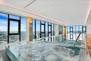 墨尔本A Cozy 2BR Apt with Panoramic Views FREE Parking的带窗户的客房内的热水浴池