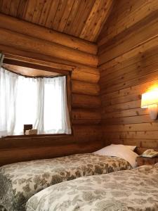 信浓log Hotel kamloops的小木屋内一间卧室,配有两张床