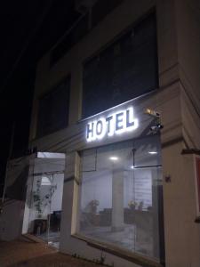 马里利亚Hotel Flat Almaru - Marília的夜间大楼一侧的酒店标志