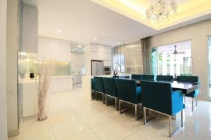 蕉赖A Spacious & Lux 4BR House with Gazebo的一间带桌子和蓝色椅子的用餐室
