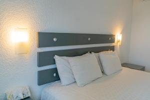 拉巴斯La Concha Beach Hotel & Club的一间卧室配有一张带两个白色枕头的床
