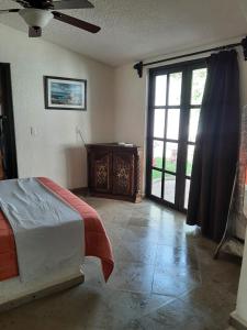 库埃纳瓦卡Quinta Edén Cuernavaca的一间卧室设有一张床和一个滑动玻璃门