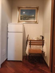 纳维廖河畔特雷扎诺Dolce Risveglio vicino Milano的厨房配有桌子和白色冰箱。