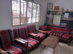 安曼Al Amawi Hostel的带沙发、桌子和窗户的客房
