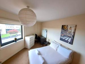 佩斯利Modern 2 Bed Apartment Close to Gla Airport & M8的卧室配有白色的床和窗户。