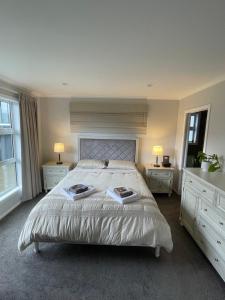 上哈特Private Ensuite with Spa in Upper Hutt的一间卧室配有一张大床、两张桌子和两盏灯。