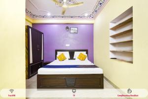 斋浦尔OYO Hotel Rajputana Homestay的一间卧室配有一张紫色墙壁的床