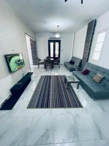 伊斯梅利亚Chalets and apartments Al-Nawras Village Ismailia的客厅配有蓝色的沙发和电视