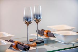 阿伯丁Mearns Street Suite ✪ Grampian Lettings Ltd的两杯酒杯坐在玻璃桌边,盘子