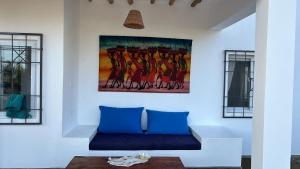 瓦塔穆Nyumbani Tamu的客厅配有蓝色的沙发和墙上的绘画