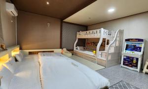 庆州GyeongJu Kids & Family Hotel的一间带双层床的卧室和一间游戏室