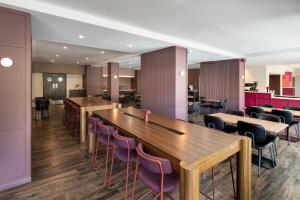 珀斯Mercure Perth On Hay的餐厅设有木桌和紫色椅子
