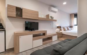 丰特-德彼德拉Cozy Apartment In Fuente De Piedra With Swimming Pool的客厅配有电视、沙发和床。
