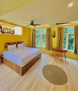乌布BAMBOO OASIS的卧室配有床、桌子和窗户。