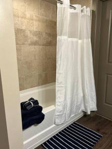 艾迪生Elite Retreat in Addison Circle的一间带白色淋浴帘的浴室