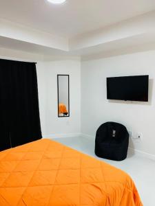 利哈伊埃克斯White house 1的一间卧室配有橙色的床和平面电视