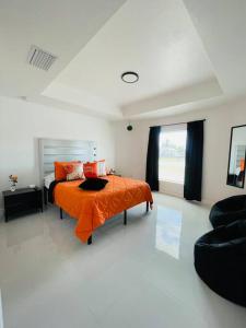 利哈伊埃克斯White house 1的一间卧室配有一张带橙色毯子的床