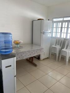 IpiocaResidencial Sauaçhuy的厨房配有桌子、冰箱和椅子