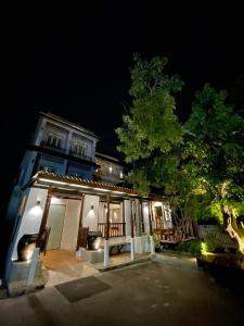 安帕瓦Thanicha Resort Amphawa的夜晚有树的房子和建筑物