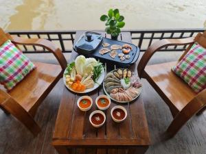 安帕瓦Thanicha Resort Amphawa的一张桌子,上面放着几盘食物