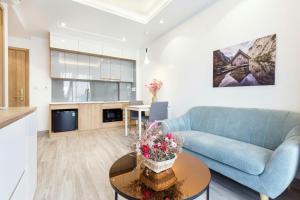 胡志明市NiNa APARTHOTEL的客厅配有蓝色的沙发和桌子