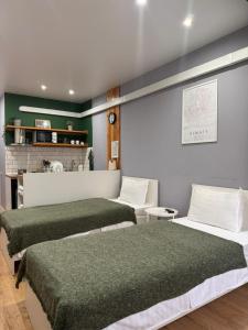 阿拉木图Evergreen Apart的绿色和白色的客房内的三张床