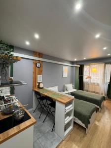阿拉木图Evergreen Apart的厨房以及带书桌和床的客厅。
