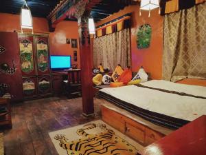 拉萨拉萨香巴拉宫精品酒店的一间卧室配有一张床和一张书桌及电视