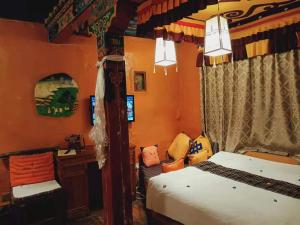 拉萨拉萨香巴拉宫精品酒店的一间卧室配有一张床、一张桌子和一台电脑