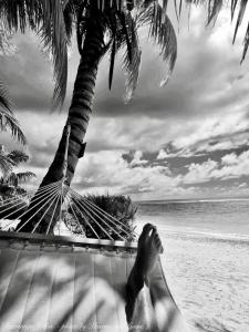 阿罗朗吉Rarotonga Villas Absolute Beachfront的躺在海滩上吊床上的人