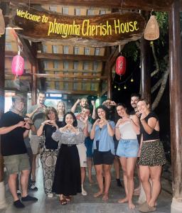 峰牙Phong Nha Cherish House的一群人,在标志下摆出一张照片
