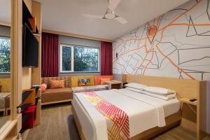 那格浦尔Ginger Nagpur Airport Road的一间卧室配有一张床,墙上贴有地图