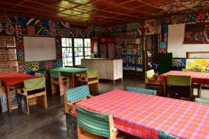 NyakinamaRoom in BB - Red Rocks Rwanda - Double Room with Shared Bathroom的餐厅内带桌椅的用餐室