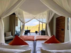珀尼达岛MAUA Nusa Penida Bali的一间卧室配有两张床,享有一个房间的景色