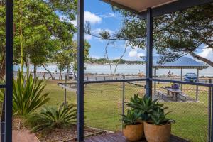坦卡里Reflections Tuncurry - Holiday Park的从种有植物的门廊上欣赏海滩美景