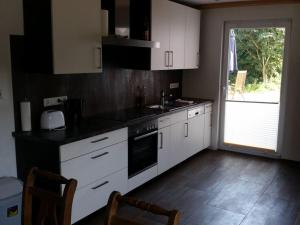 博尔库姆Borkum Freedom 2的厨房配有白色橱柜和黑色台面