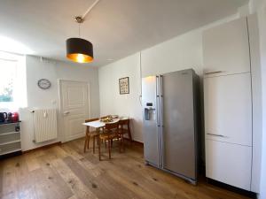 DerendingenBusiness Apartment in Derendingen的厨房配有桌子和不锈钢冰箱。