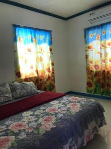 桑坦德Joy O Hoy Beach House的一间卧室设有一张床和两个鲜花窗户。