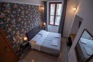比萨弗朗切斯科酒店的一间小卧室,配有床和花卉墙