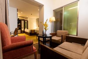达卡孟加拉金丝雀公园酒店的客厅配有沙发和桌子