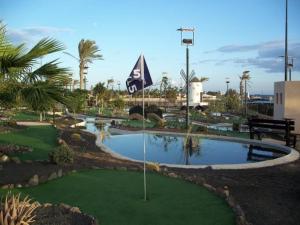 La GuirraEl Castillo Golf Salinas-wifi的一个带果岭和旗帜的高尔夫球场