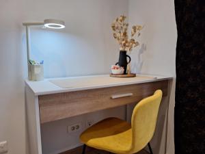 阿让Chambre GUSTAV的一张带黄色椅子和镜子的桌子