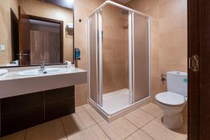 唐贝尼托Hotel Tierra的带淋浴、卫生间和盥洗盆的浴室