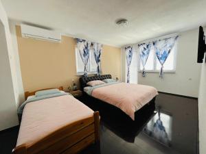 比哈奇Summer house LejHana的一间卧室设有两张床和两个窗户。