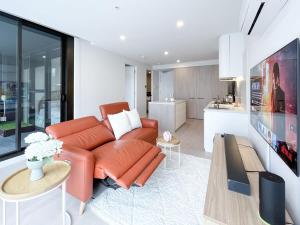 格伦韦弗利Modern Luxury 2B2B Sky Garden SmartTV的一间带橙色沙发的客厅和一间厨房