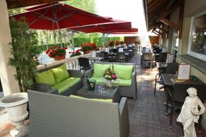 埃佩尔奈罗基斯巴格特尔酒店- 51530 迪斯的一个带桌椅和遮阳伞的户外庭院。