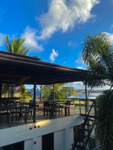公主港Mojo Hostel的海滩上拥有桌子和棕榈树的餐厅