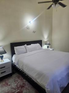 法尔茅斯Stonebrook Villa的卧室配有白色的床和吊扇