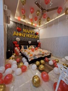 法里达巴德Aagman Stays By Kasa Lusso的一间设有气球的房间和一张有快乐周年纪念标志的床